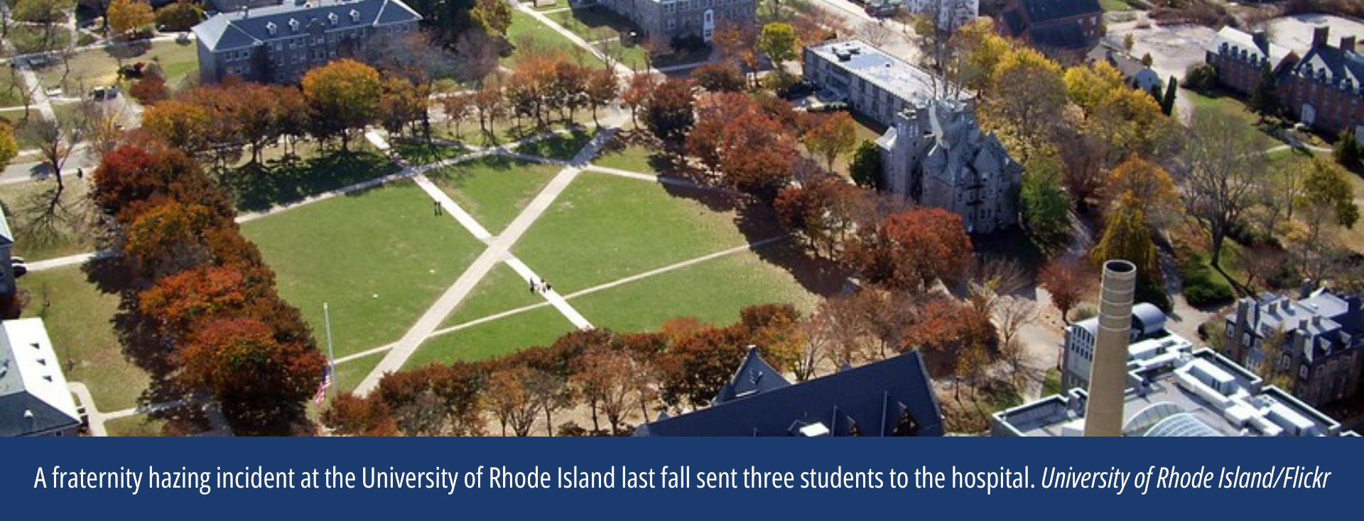 Aerial view of a campus quad with green grass and sidewalks, surrounded by college buildings.